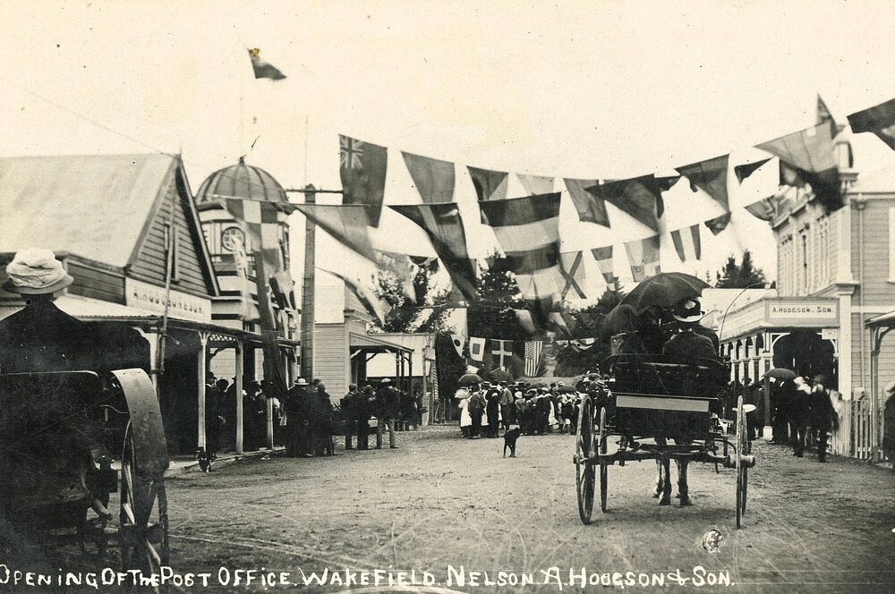 Black and white image of the street in front of the post office filled with people.